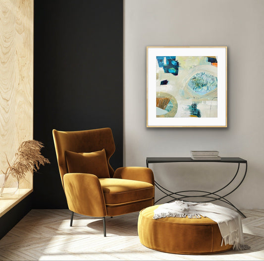 Modern interior with a mustard yellow armchair, ottoman, and abstract art print "Beachcombing" by Alison Gilbert Art, on the wall.