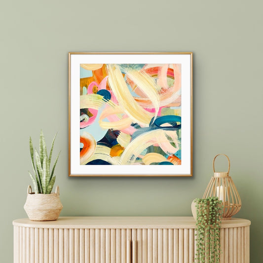 Framed abstract artwork print by Alison Gilbert Art on a wall with decorative items below