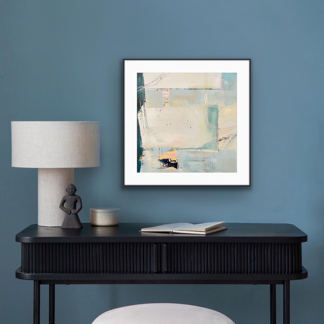 Framed abstract art print on paper, 'Harbour', on a blue wall above a black console table with decor items.