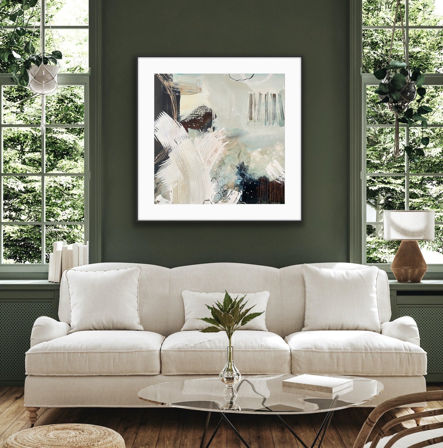 Living room with a white sofa, abstract art print "Siren'e Swell" on the wall, and decorative elements.