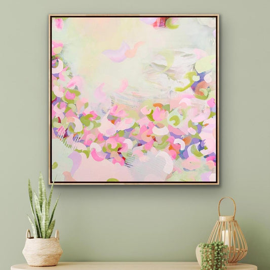 Framed pink abstract Alison Gilbert canvas print 'Spring Serenade' on a green wall, accompanied by decorative plants and a lantern.