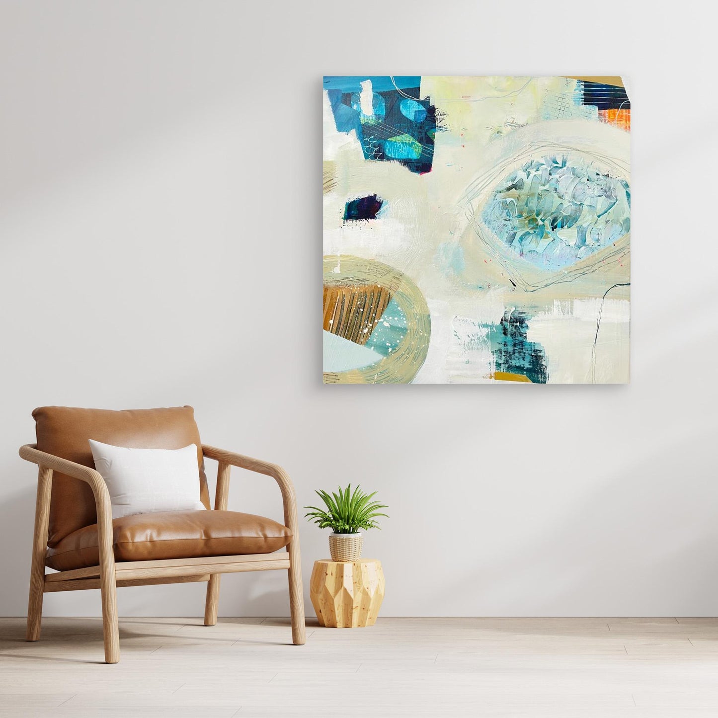'Beachcombing'  abstract framed canvas print on a wall above a brown armchair with a plant on a wooden side table.
