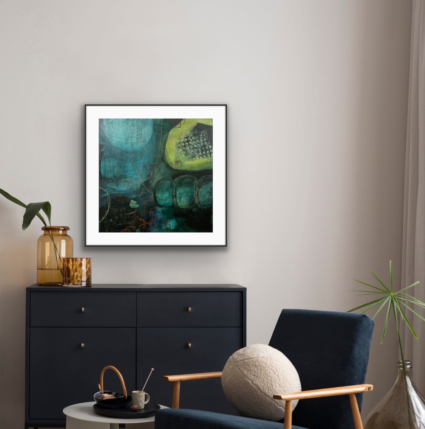 Framed abstract print "Behind the Waterfall" on a wall above a black dresser with decorative items.