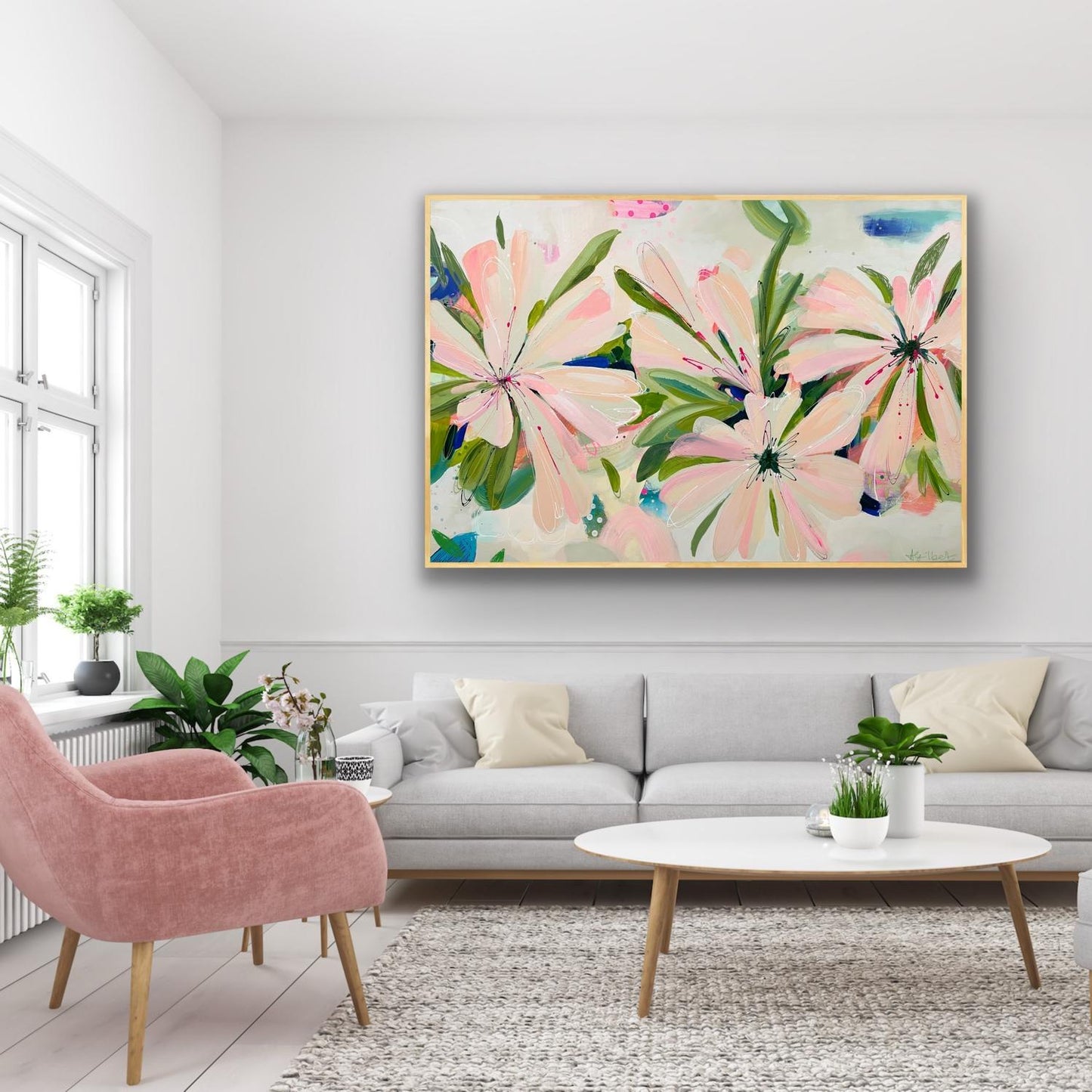 Living room with a floral Canvas Art Print 'Bellini Blooms' on the wall, pink armchair, and gray sofa.