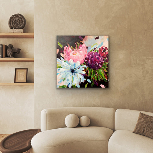 Floral painting 'Blowsy Blooms' on a wall above a beige sofa in a living room setting.