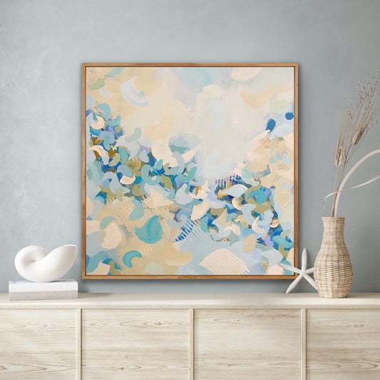 Abstract Alison Gilbert canvas print 'Blue Blossom'  in a wooden frame on a wall above a shelf with decorative items.
