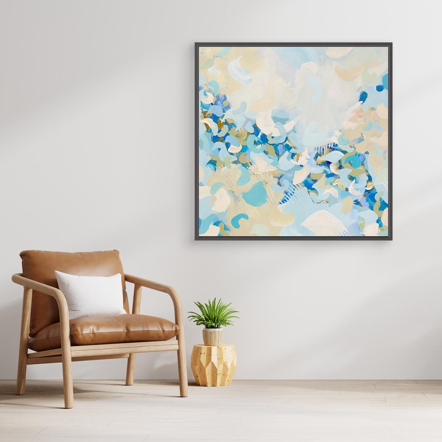 Abstract canvas print 'Blue Blossom' from Alison Gilbert in a modern living room with a brown chair and plant. 