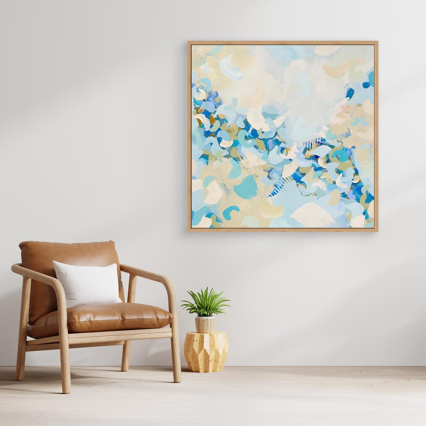 Abstract canvas print 'Blue Blossom' from Alison Gilbert in a modern living room with a brown chair and plant. 