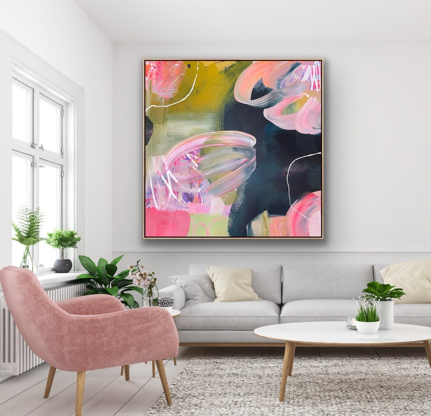 Living room with a pink armchair, gray sofa, and abstract Alison Gilbert canvas print 'Bubblegum' on the wall.