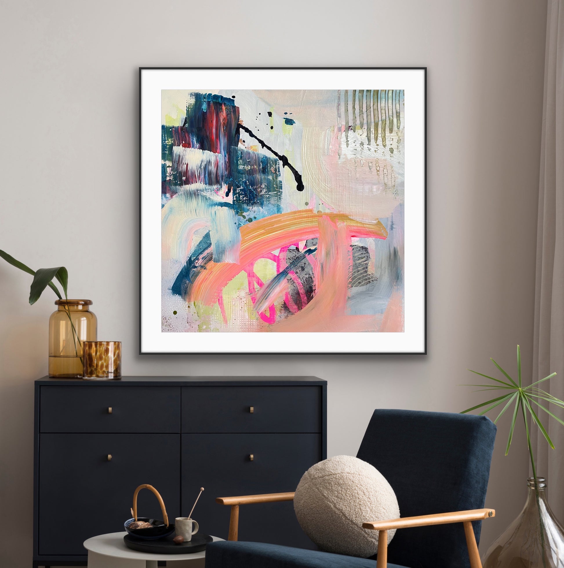 Framed abstract giclee print "Chaos" from Alison Gilbert Art, in a modern living room setting with a black cabinet and blue armchair.