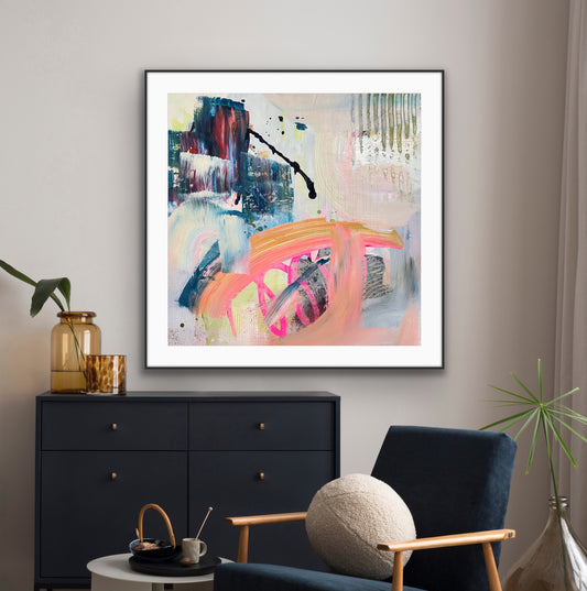 Framed abstract giclee print "Chaos" from Alison Gilbert Art, in a modern living room setting with a black cabinet and blue armchair.