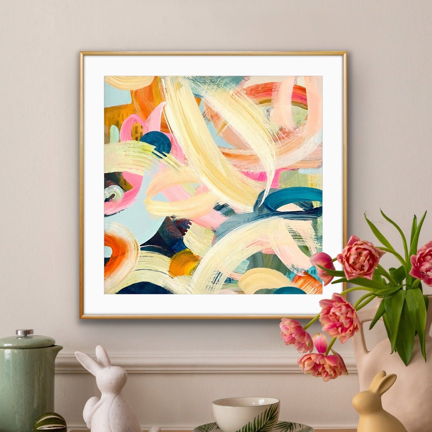 Colorful abstract print by Alison Gilbert Art on a wall above a wooden table with decorative items.
