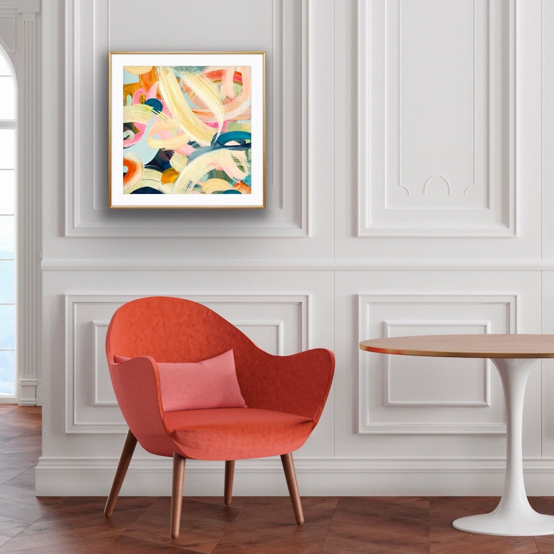 Modern interior with a red chair, pink pillow, and abstract art print "Freewheeling" by Alison Gilbert Art, on a white wall.