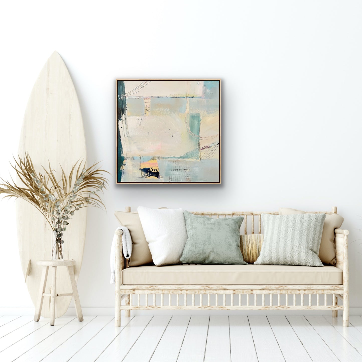 Abstractcoastal themed art canvas print on a white wall above a rustic sofa with dried grasses and a painted wooden fllor