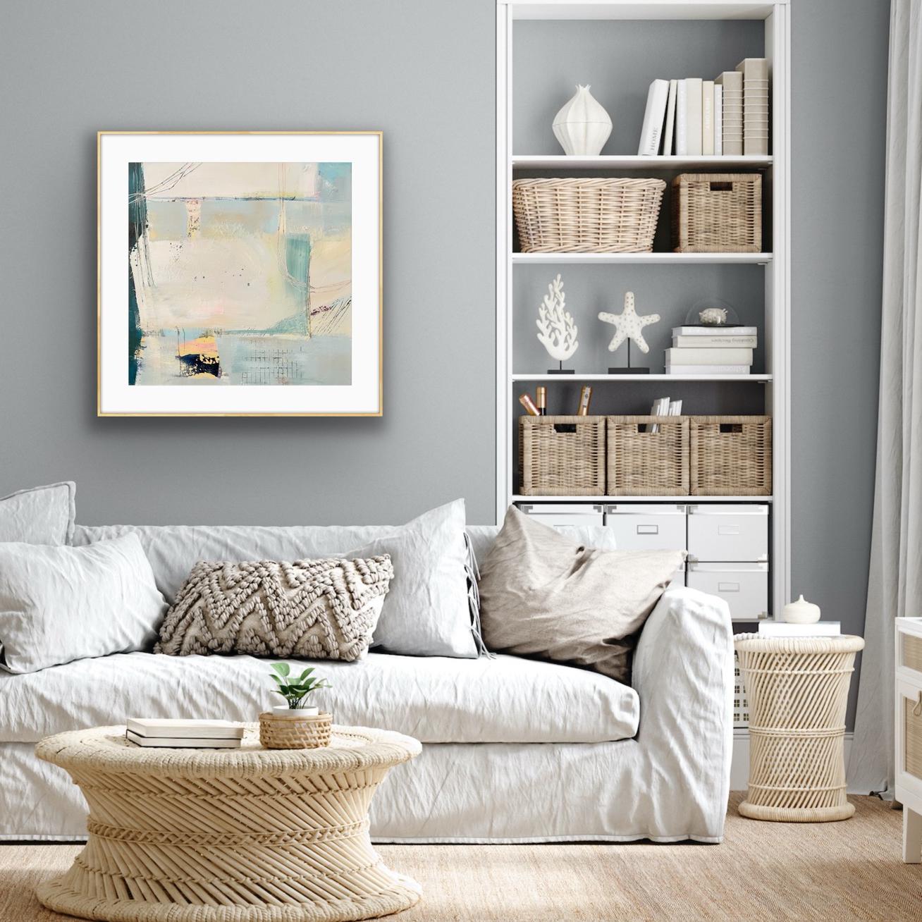 Living room with a white sofa, coffee table, and a framed art print on paper 'Harbour', against a grey wall.