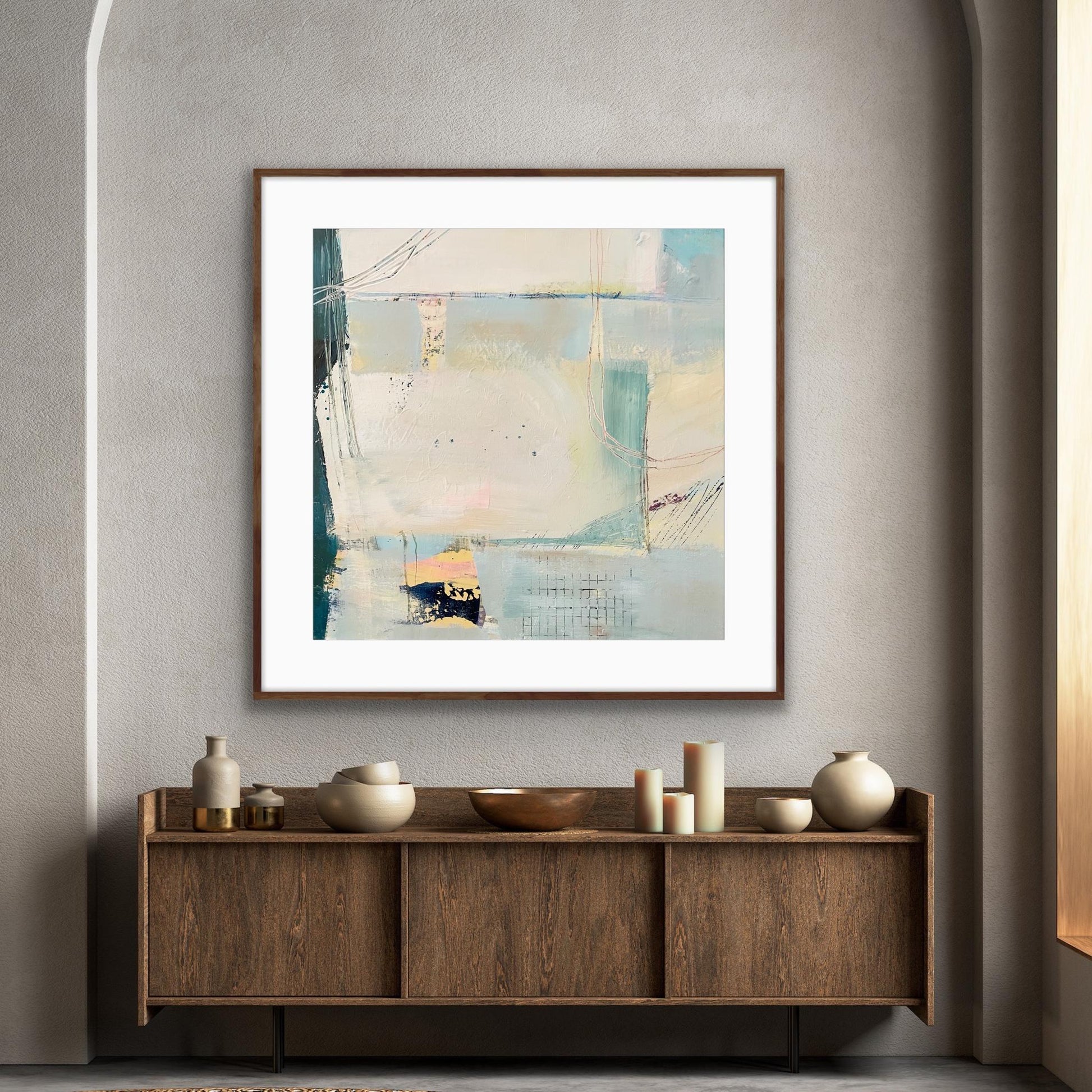 Abstract framed art print 'Harbour' in a wooden frame on a wall above a wooden console table with decorative items.