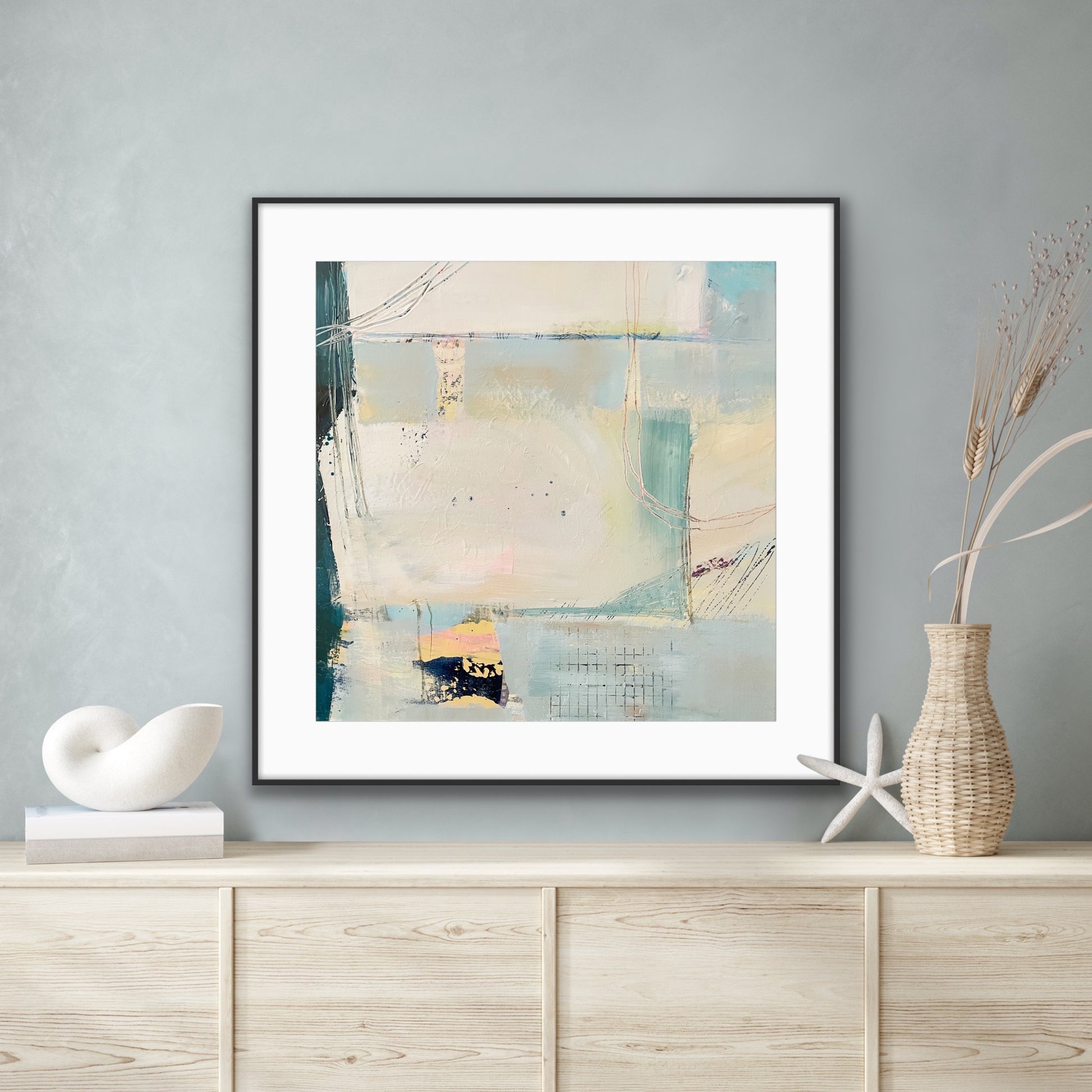 Framed abstract 'Harbour' Art Print on Paper, on a wall above a wooden cabinet with decorative items.