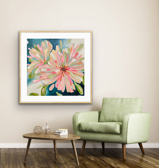 'Bloom Large' Framed Art Print on Paper on a white wall above a green armchair in a living room.