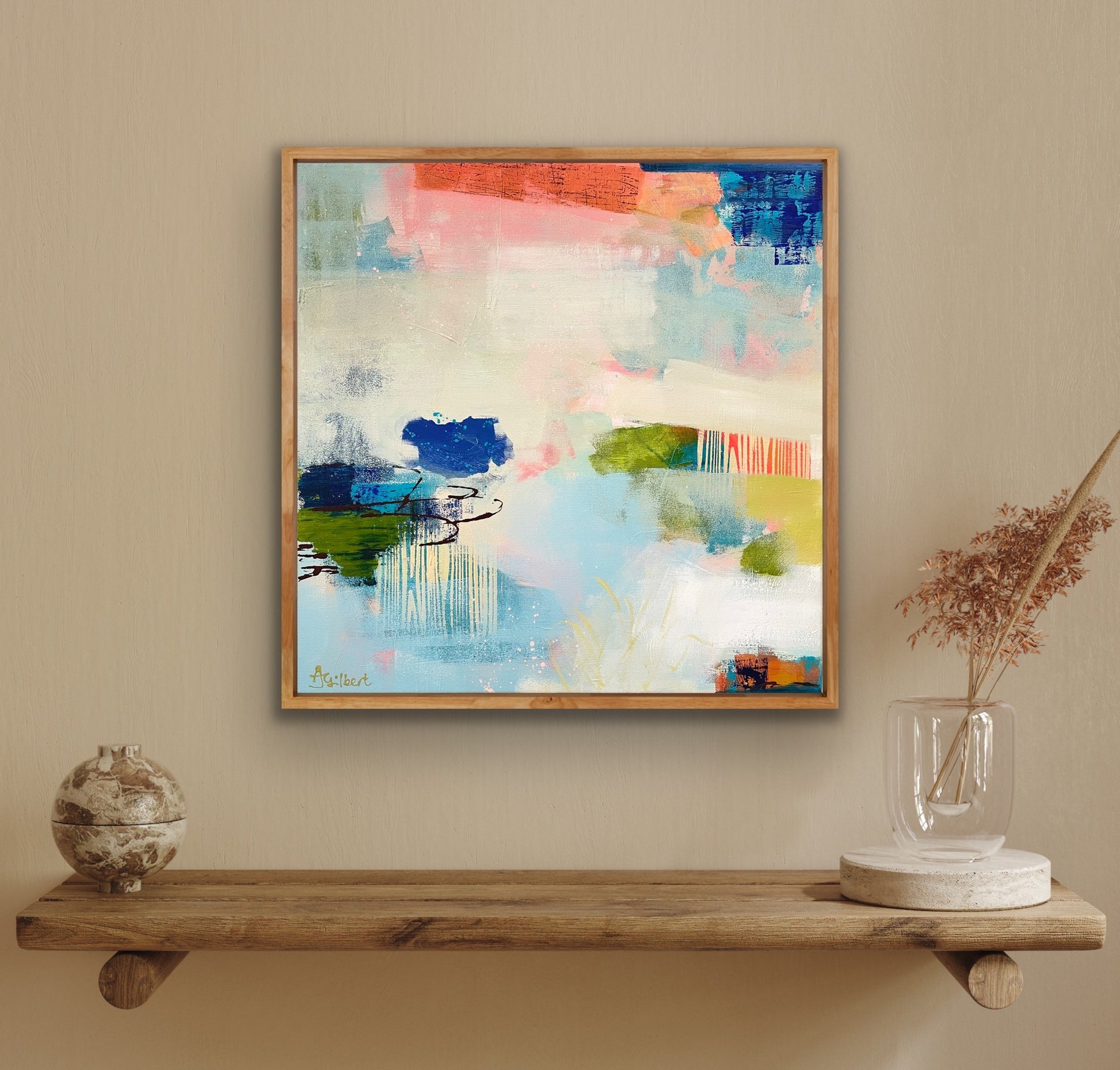 Abstract print by Alison Gilbert Art on a wall above a wooden shelf with decorative items.