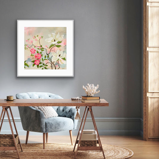 Framed floral Print 'Maytime Magnolias' artwork on a gray wall above a wooden desk with a chair.