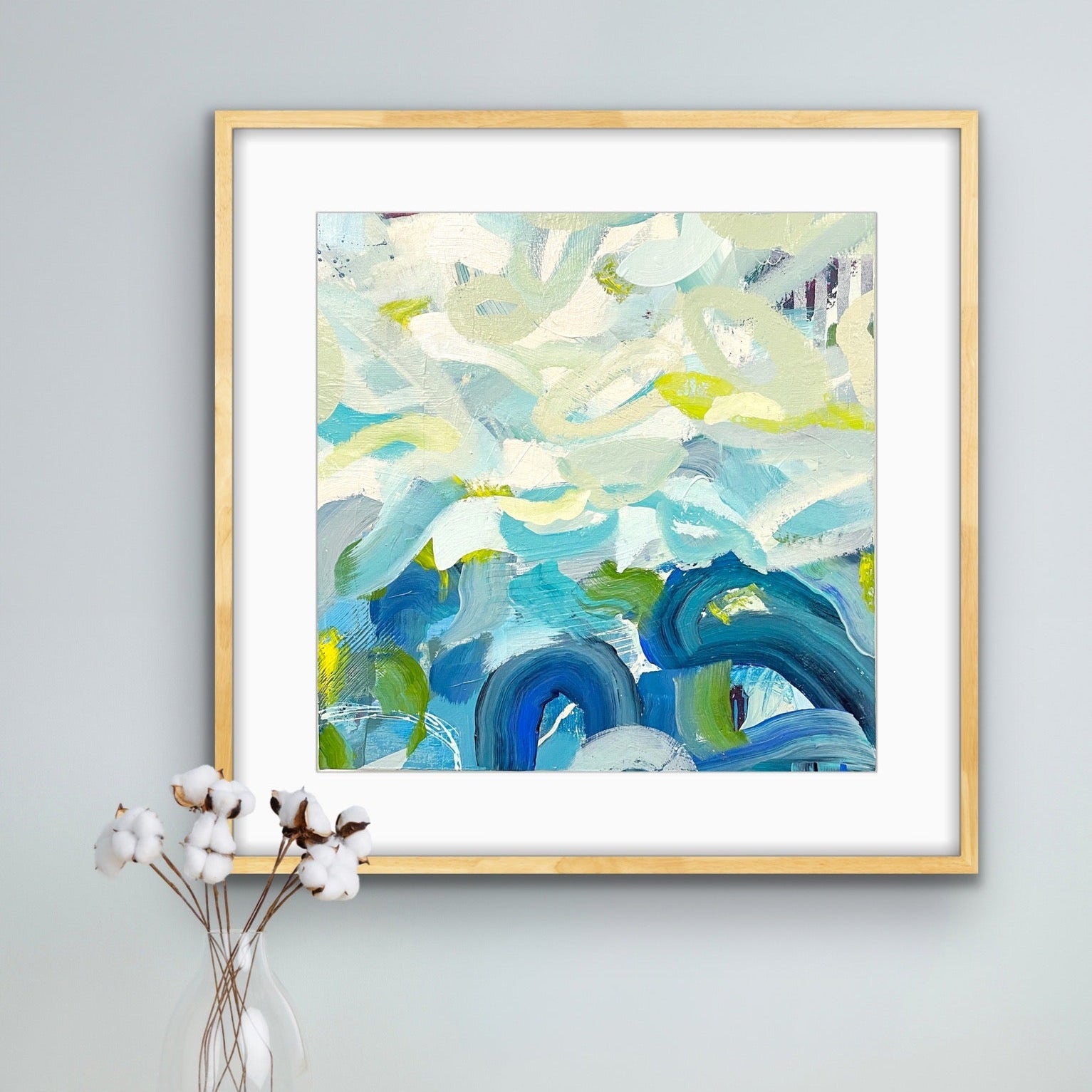 Framed abstract art print 'Outward Expression' by Alison Gilbert Art on a gray wall above a wooden surface with a vase and cup.