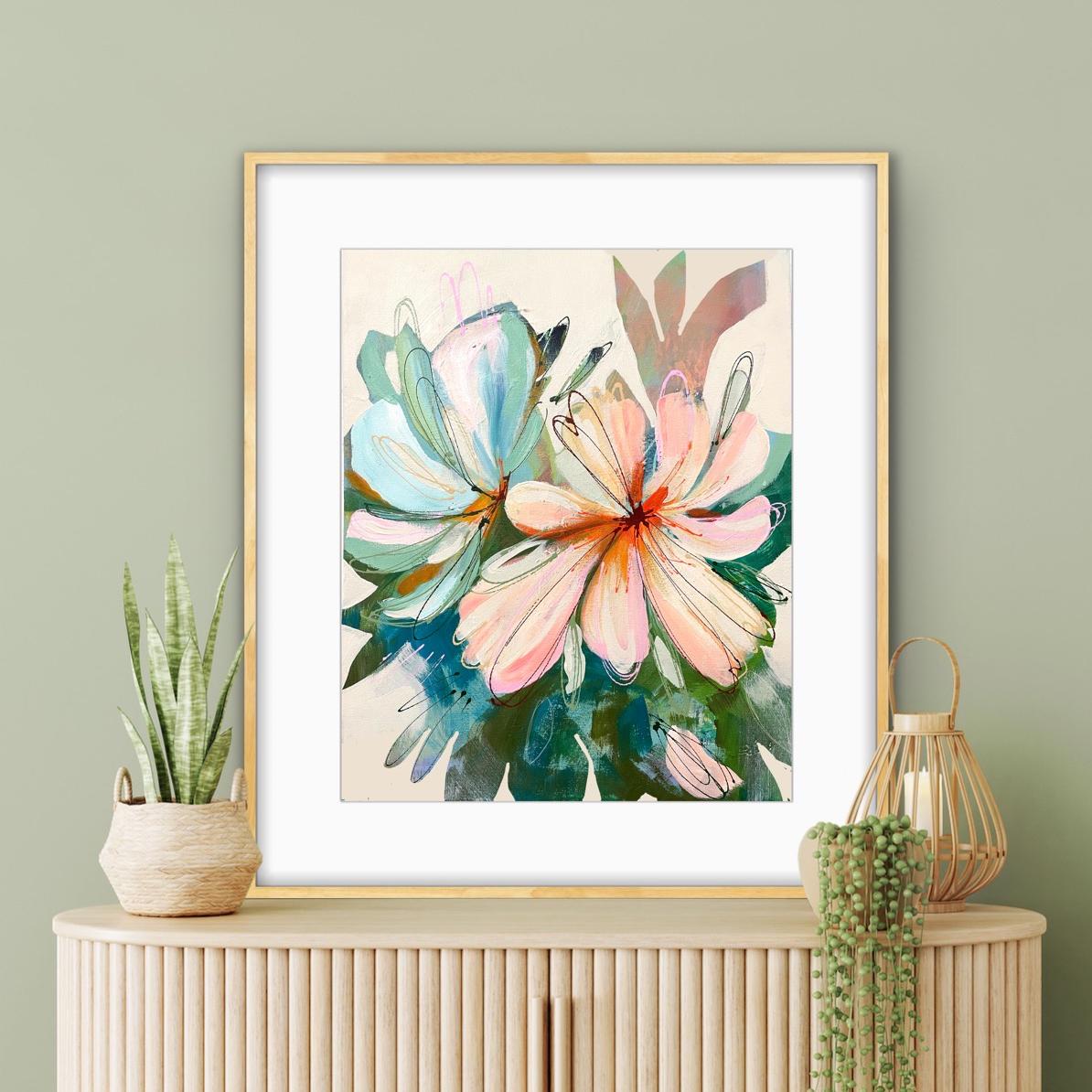 Framed abstract floral print of peach  propped on a console with potted plants