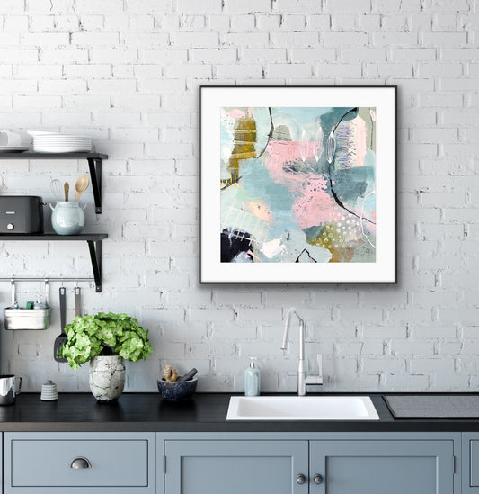 Framed abstract art print "Shallow Pool" by Alison Gilbert Art on a kitchen wall with white brick tiles.