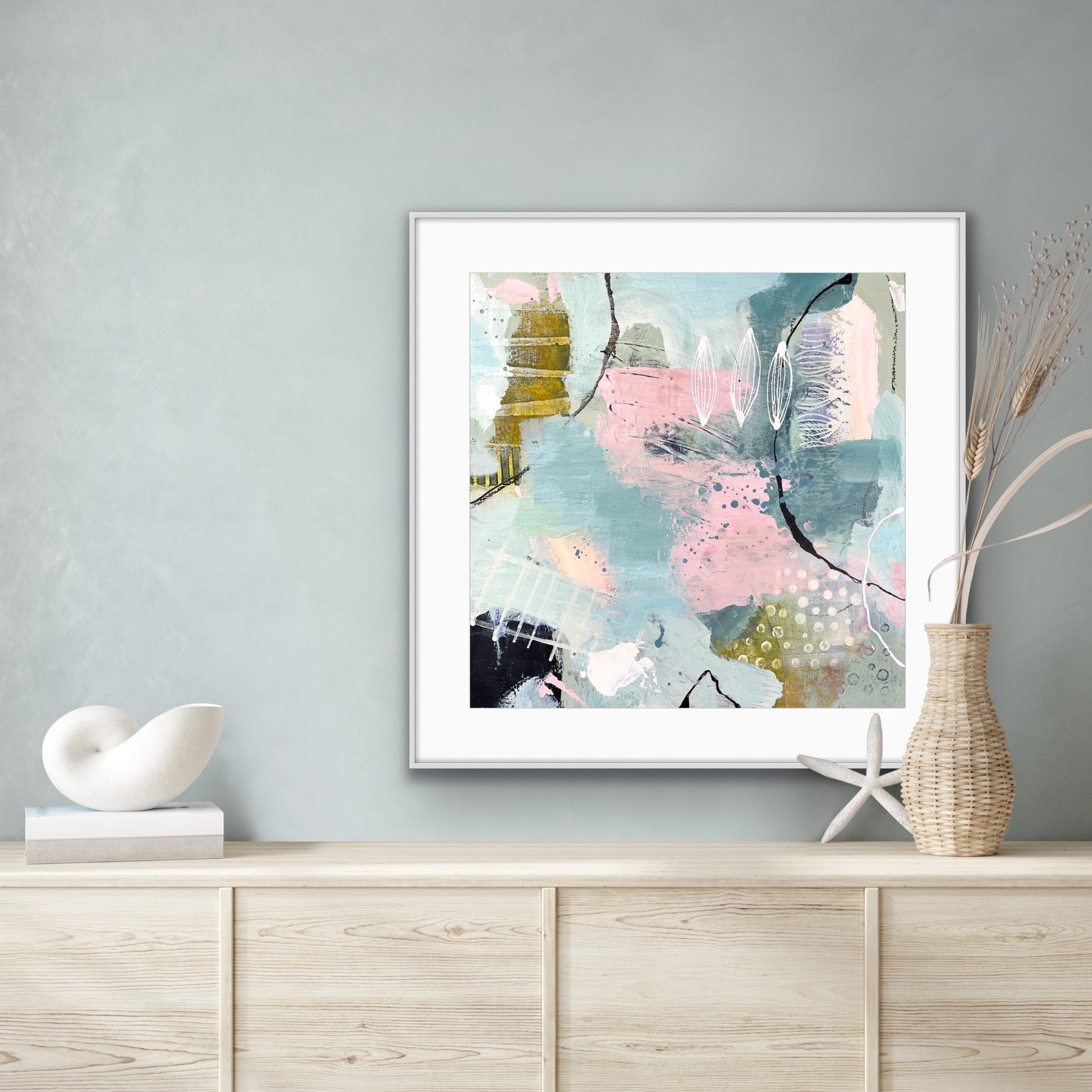 Framed abstract giclee print "Shallow Pool" from Alison Gilbert Art, on a wall above a wooden cabinet with decorative items.