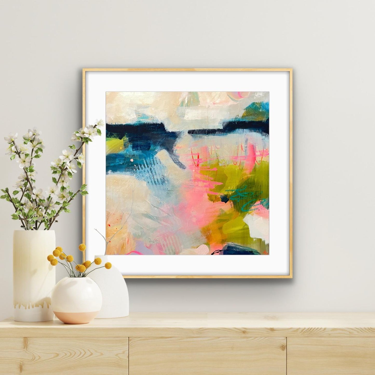 Framed art print 'Shepherd's Delight' on a wall above a wooden shelf with decorative items.