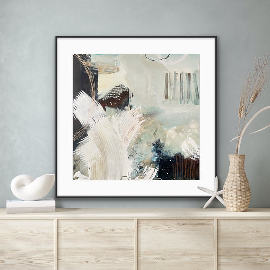 Framed abstract art print "Siren's Swell" by Alison Gilbert Art, on a wall above a wooden cabinet with decorative items.