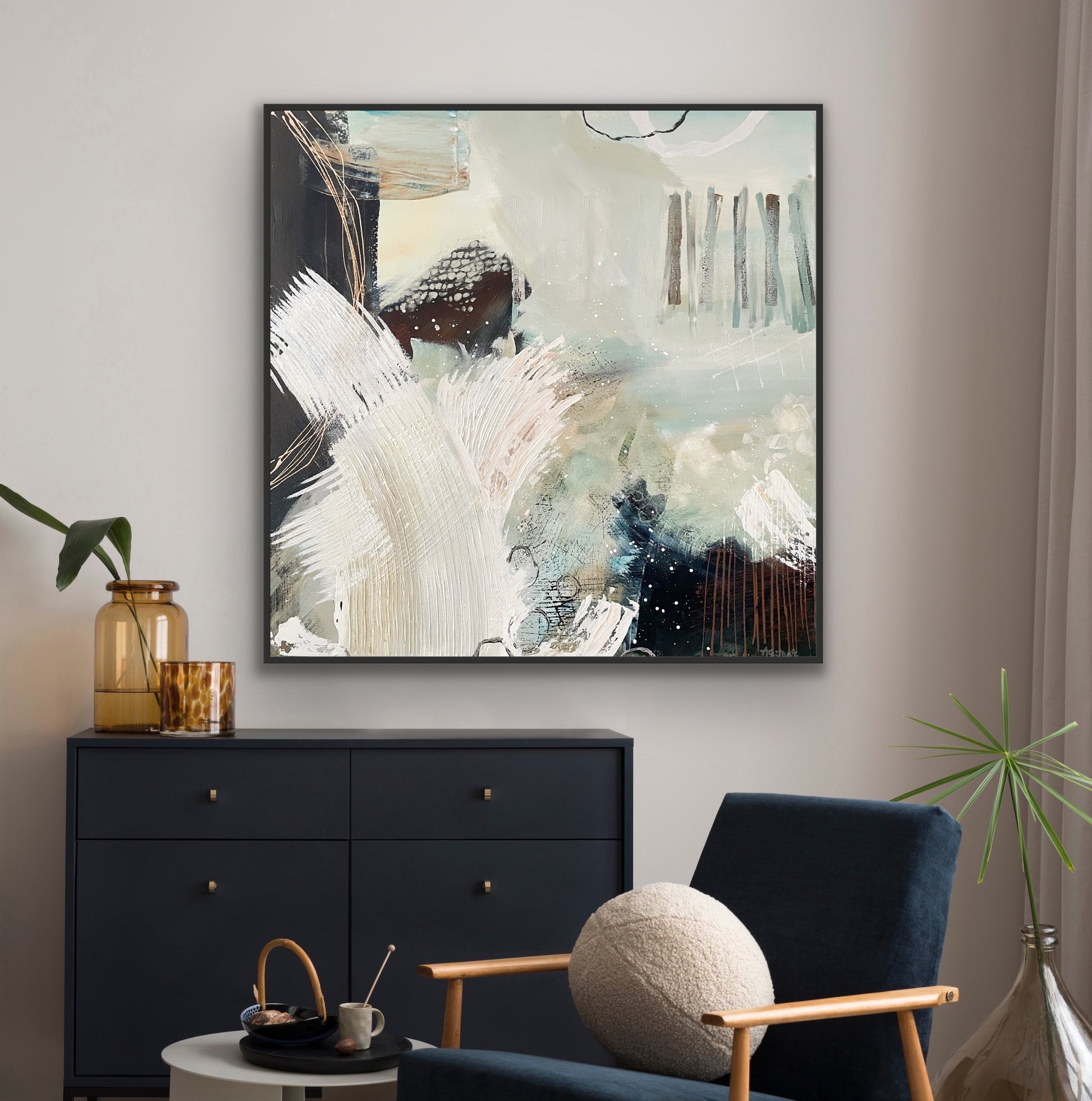 Abstract canvas print 'Siren's Swell' by Alison Gilbert Art on a wall above a black dresser with a blue chair and decorative items.