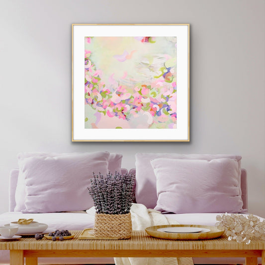 Framed pastel coloured abstract art print "Spring Serenade" by Alison Gilbert Art, on a wall above a sofa with decorative items.rt