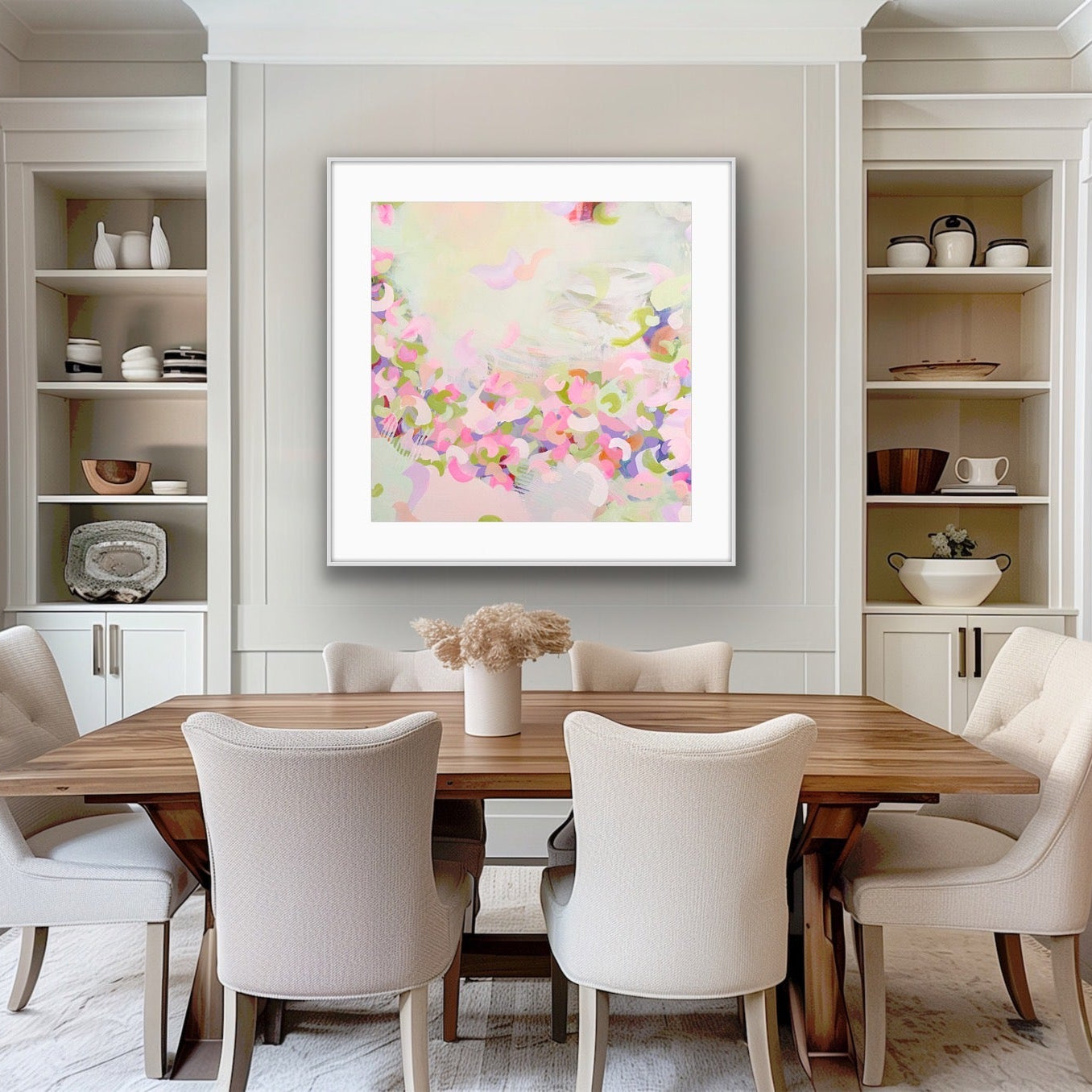 Dining room with a wooden table and white chairs, featuring a soft pastel coloured abstract print on the wall.