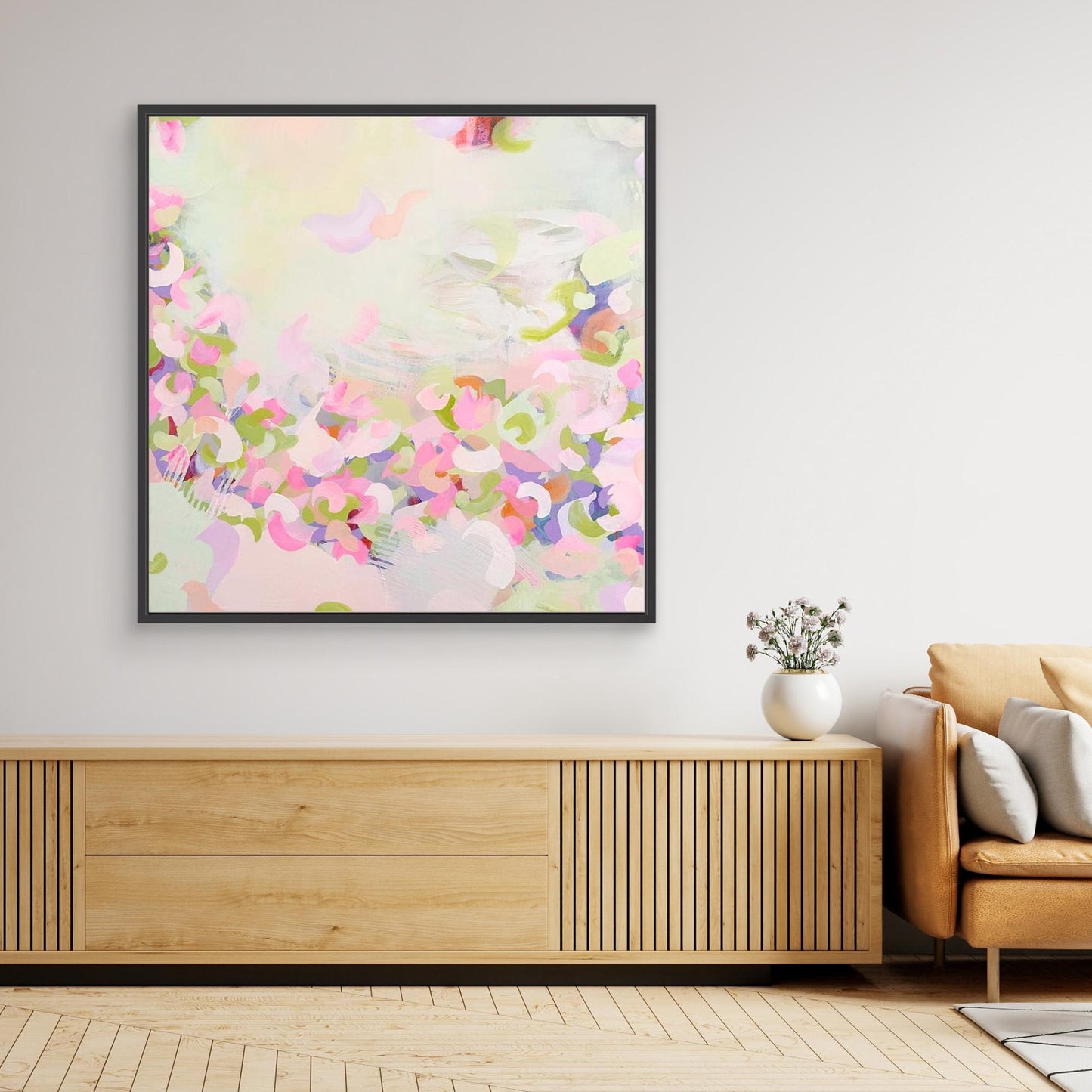 Framed pink abstract canvas print 'Spring Serenade' on a wall above a wooden console table.