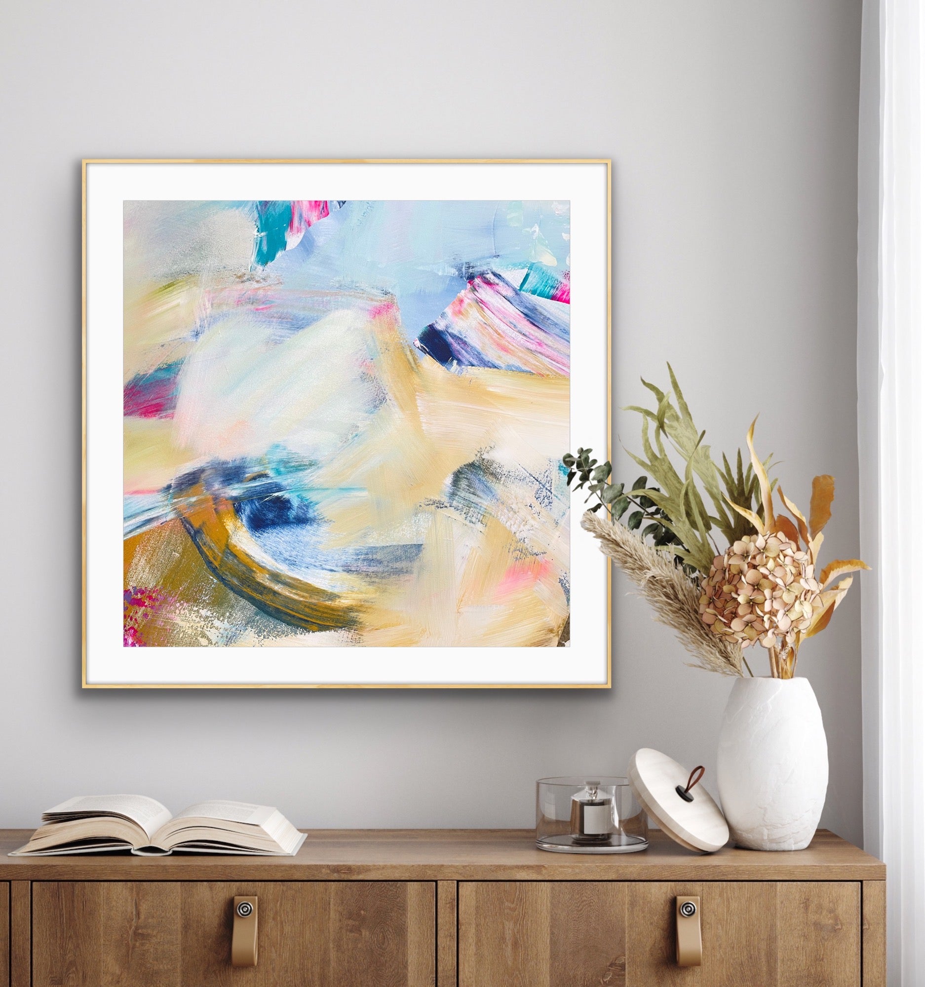 Abstract giclee art print "Summer Breeze" from Alison Gilbert Art, in a gold frame on a wall above a wooden cabinet with decorative items.