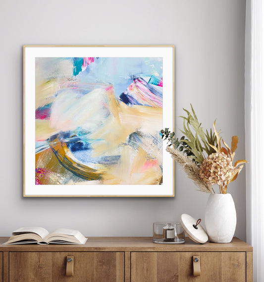Abstract giclee art print "Summer Breeze" from Alison Gilbert Art, in a gold frame on a wall above a wooden cabinet with decorative items.