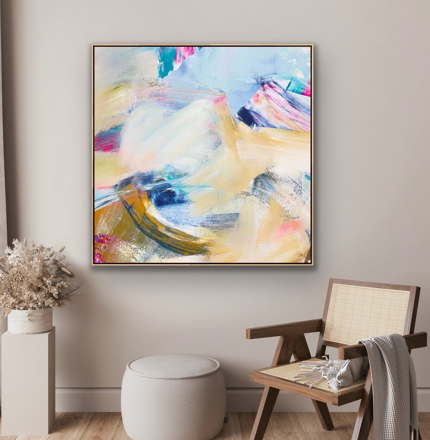 Abstract Alison Gilbert canvas print 'Summer Breeze' on a wall above a chair and side table in a room.