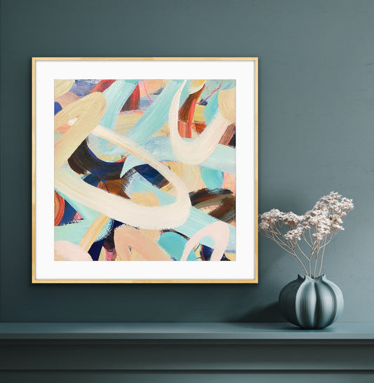 Framed abstract art print 'Twist & Shout' on a dark wall with a vase of flowers below.