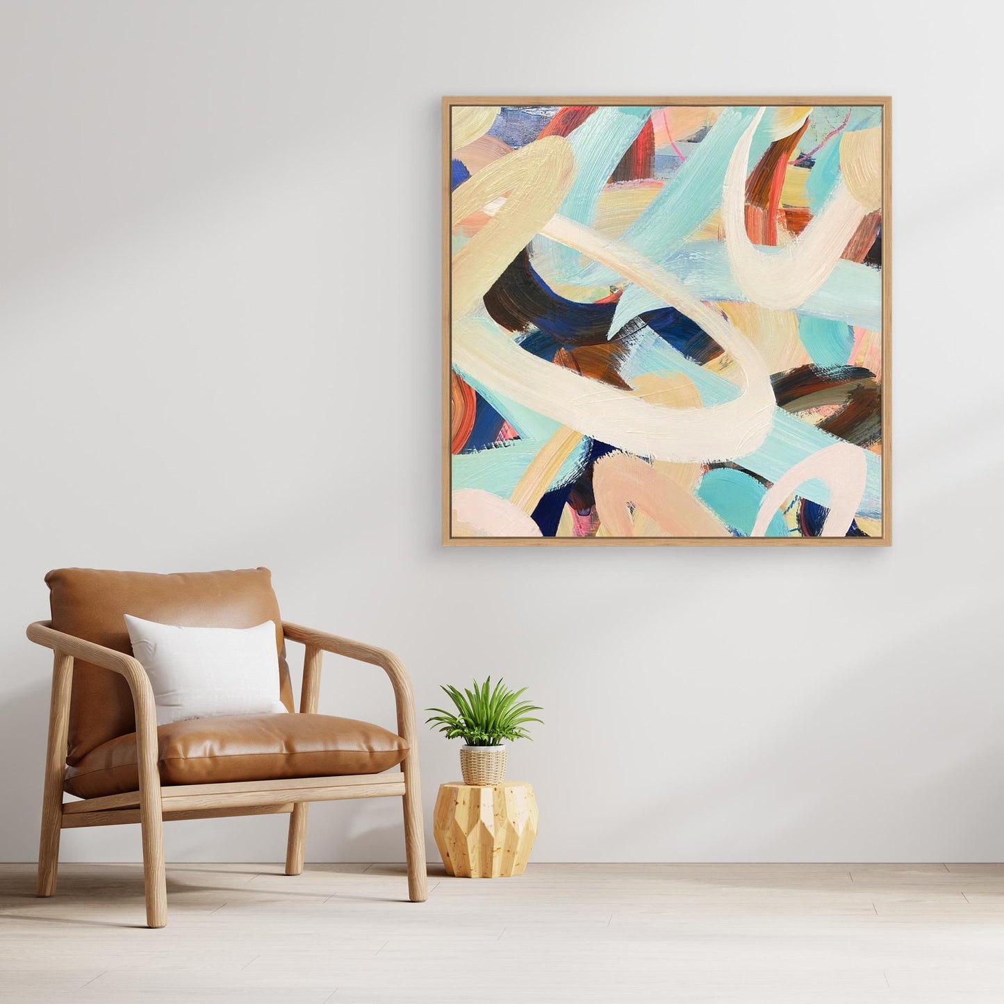 Modern interior with a brown leather chair, small table, and abstract Alison Gilbert canvas print 'Twist and Shout' on the wall.