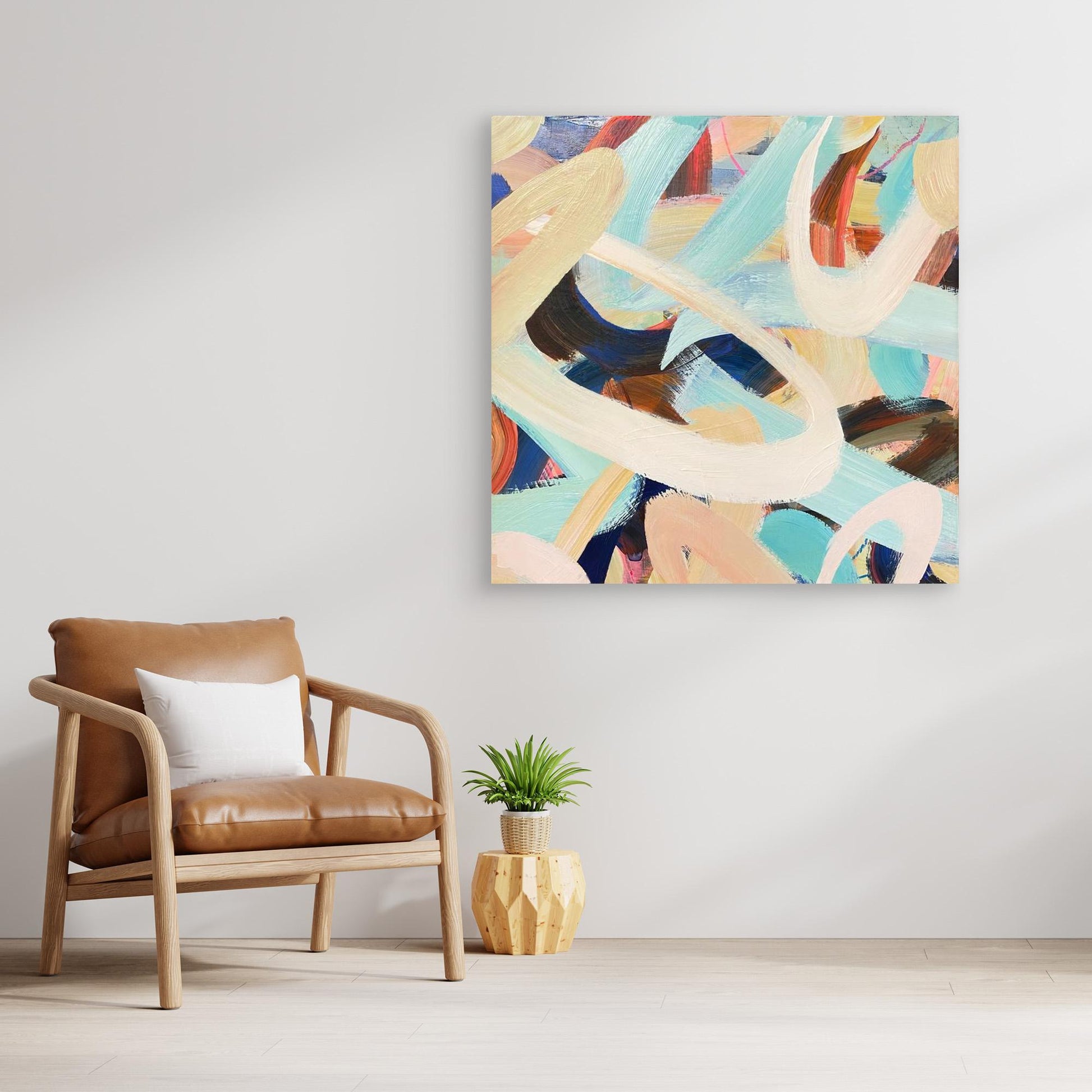 Abstract Alison Gilbert canvas print 'Twist and Shout' on a wall above a brown armchair with a plant on a wooden side table.