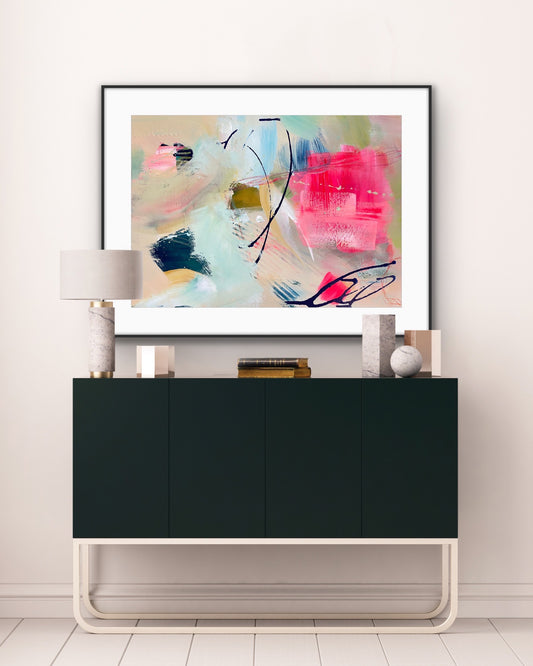 'Unexpected Arrival' Framed Print on Paper on a wall above a black cabinet in a room.