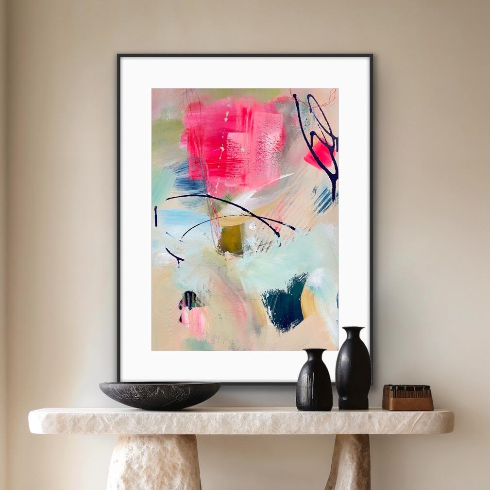 Framed abstract art print 'Unexpected arrival' on a wall above a console table with decorative items.