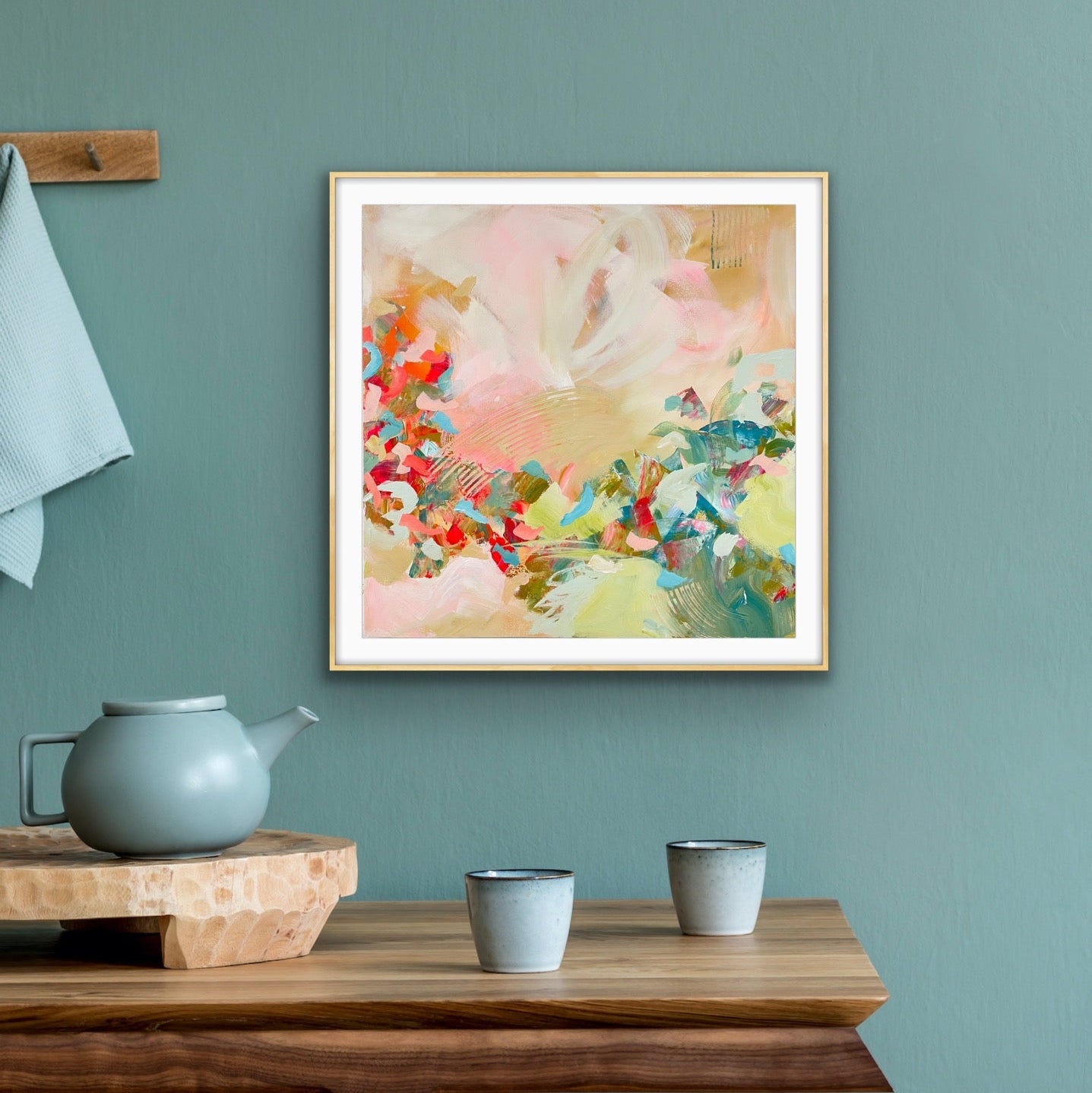 Framed abstract art print "Whispers of a New Day" from Alison Gilbert Art, on a teal wall with a wooden table and teapot.