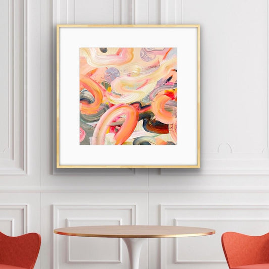 Framed abstract art print 'Wurlitzer' with wavy patterns in pink, orange, and black on a white wall.
