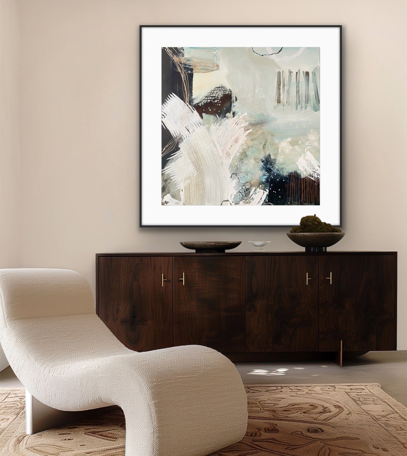 Modern interior with a white lounge chair, dark wooden cabinet, and framed abstract art print "Siren's Swell" on a beige wall.