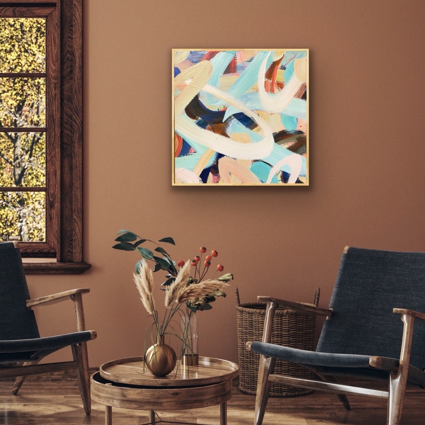 Living room with abstract art canvas print from Allison Gilbert Art on the wall, two chairs, a coffee table with a vase, and a window.